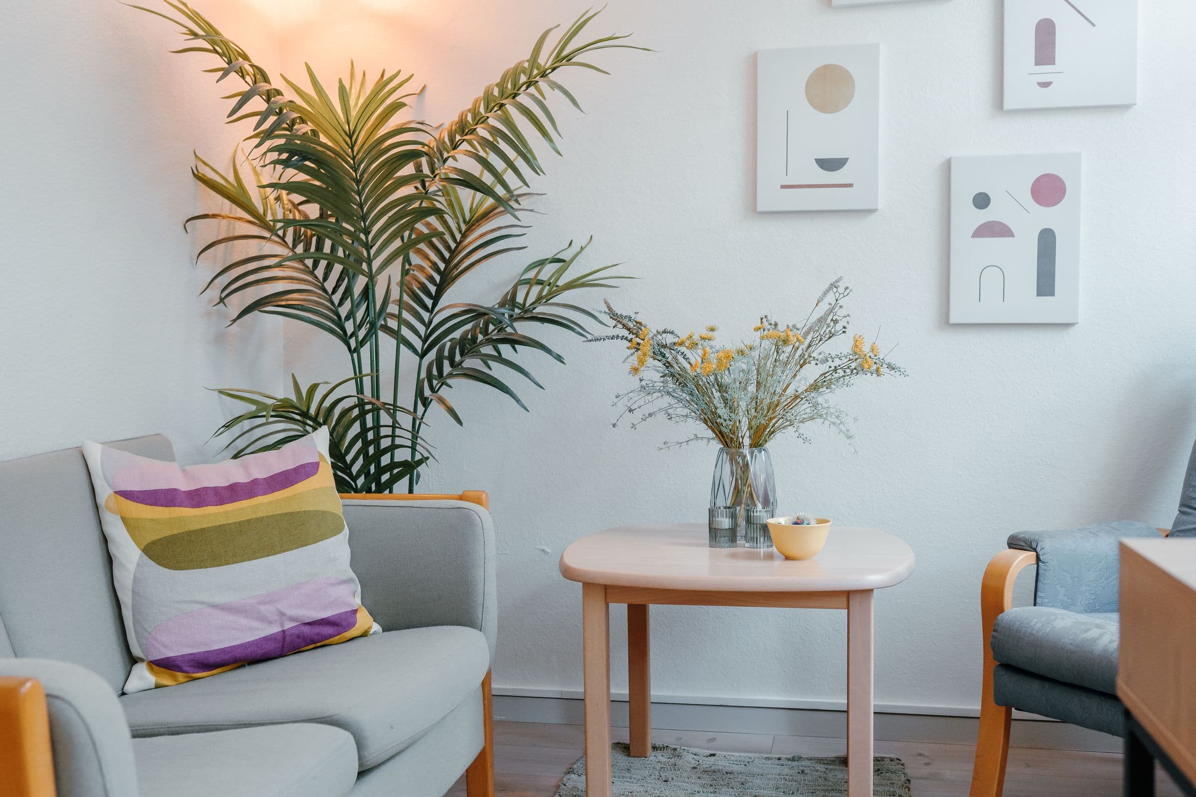 Samtalerum med lyse lænestole, blomster og planter
